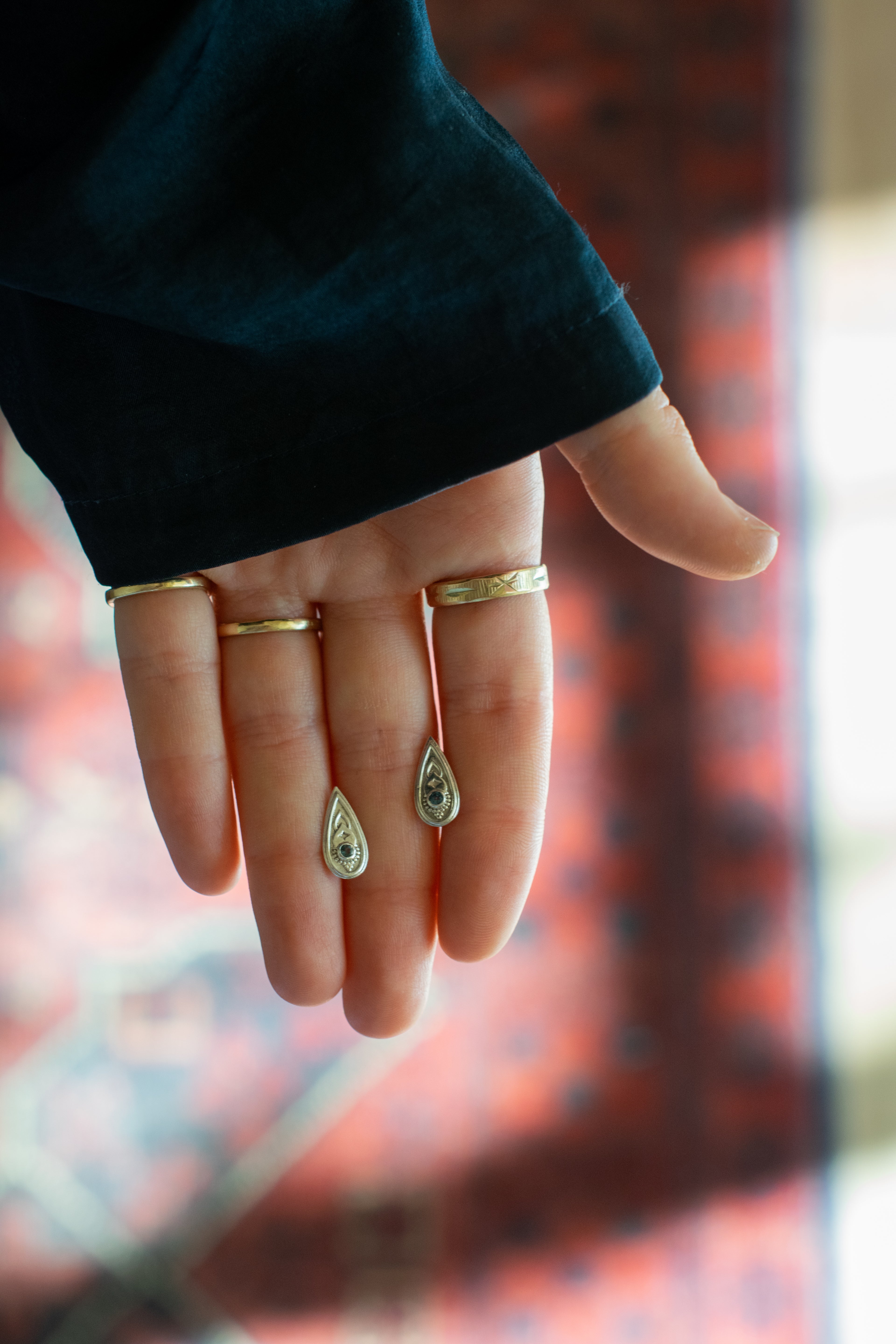  two silver teardrop-shaped earrings set whith blue gemstones