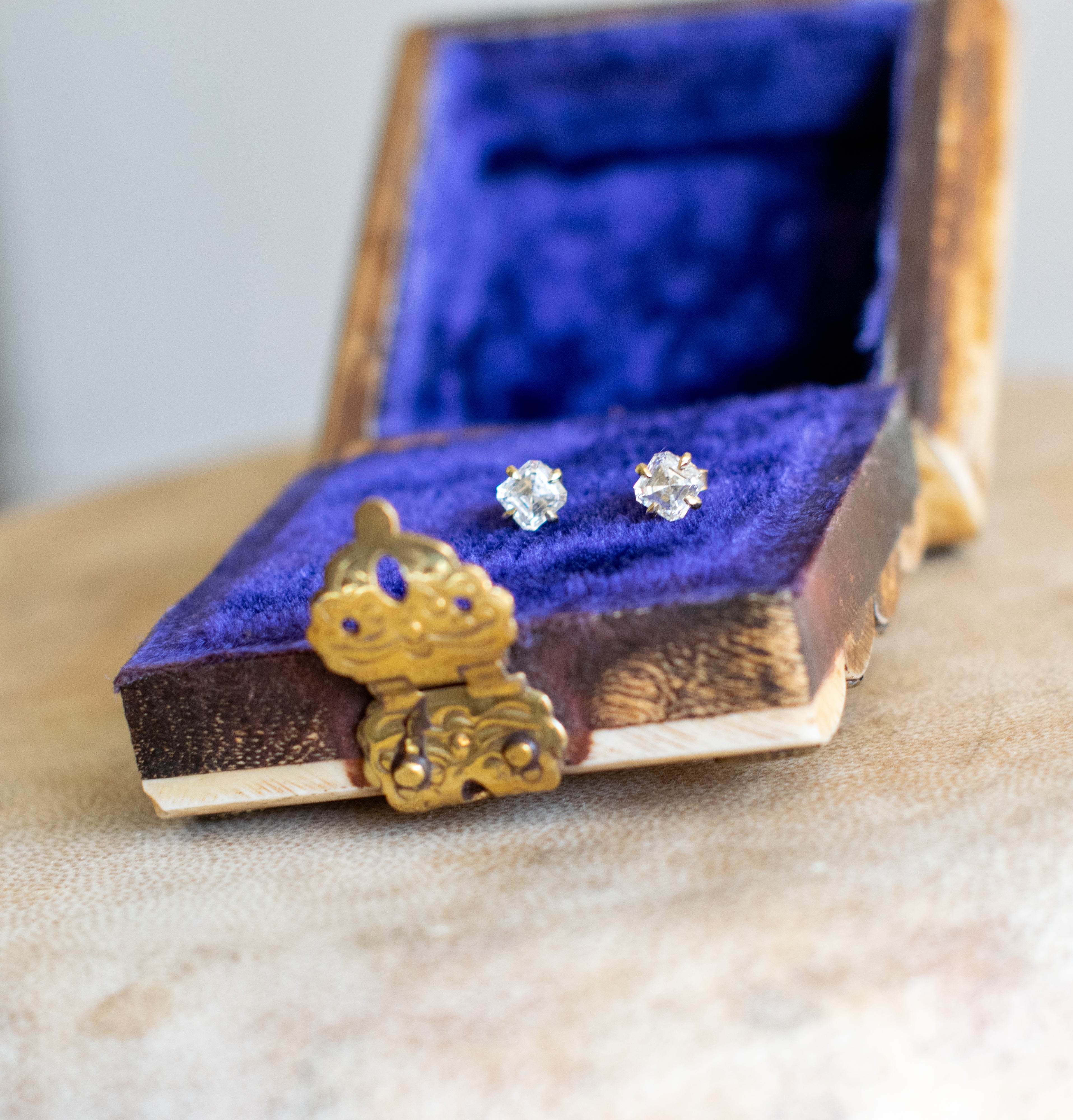 Gold asscher cut diamond stud earrings on a jewelry box