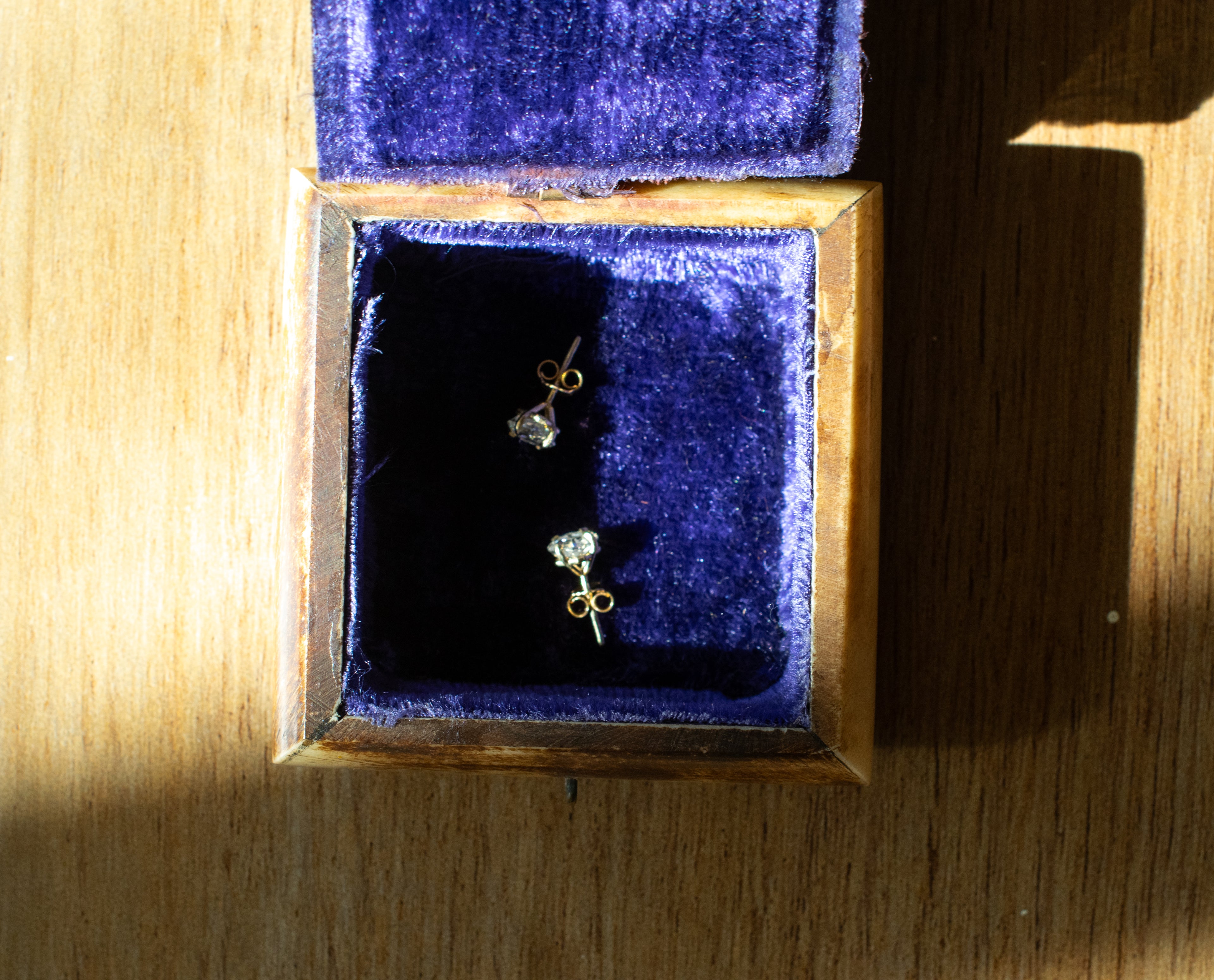Gold asscher cut diamond stud earrings in a jewelry box